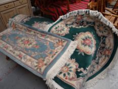 A large green & cream patterned Chinese rug together with a matching patterned circular rug & a pale
