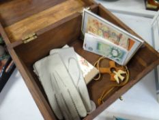 A hardwood box containing a pair of leather gloves, a £1 note, ten shilling note & a 1977