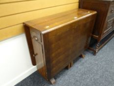A vintage oak drop leaf dining table with cupboard & drawer ends