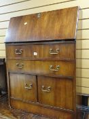 A vintage mahogany narrow drop down bookcase with brass handles