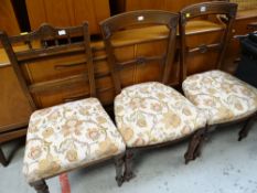 Three upholstered oak dining chairs