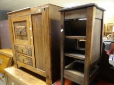 A carved oak decorated cupboard together with a plant stand