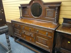 An Edwardian mirror backed oak sideboard with carved decoration & on raised barley-twist legs