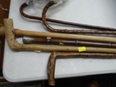 A parcel of six vintage walking sticks including one with a hallmarked silver top