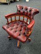 A modern red leather buttoned captain's chair