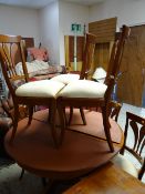 A modern polished wood extending circular dining table by Grange together with six matching dining