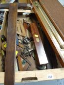 Collection of various vintage technical drawing equipment including rulers, set squares, tape