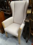 A modern lightwood & upholstered wingback armchair