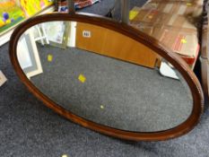 An oval mahogany framed bevel glass mirror