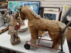 A stuffed child's baby walker in the form of a horse together with a pottery figure of a girl