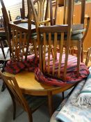 A 1970s G-Plan circular extending dining table together with 6 + 2 matching dining chairs