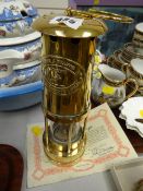 A brass miners lamp together with a certificate of origin made by E Thomas & Williams, Ltd