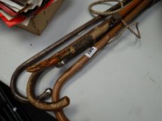 A parcel of walking sticks together with a riding crop