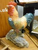 Excellent carved model of a painted cockerel on a branch, approx 18 ins high
