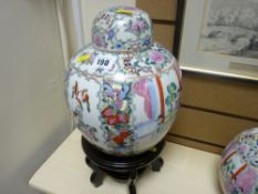 Oriental ginger jar with lid on a hardwood stand, 10 ins high