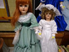 Two dolls, one with red hair and green check dress and the other in bridesmaid's dress and bonnet