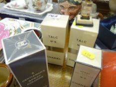 Quantity of still packaged Chanel No. 5 products with a vintage bottle in stand