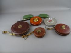 Collection of vintage reel-in surveyor's tape measures by Raybone with two Holbro desk weights
