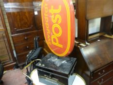 Black metal deed box with key and a red Post Office wall sign