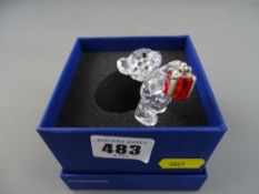 Swarovski crystal model of a teddy bear carrying a red parcel