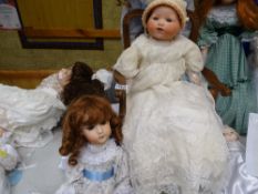 Armand Marseilles doll in cream lace floral dress seated on an elbow chair and another doll with