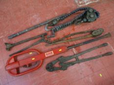 Parcel of heavy metal equipment, large metal chain wrench, bolt cutters and red car mechanic's