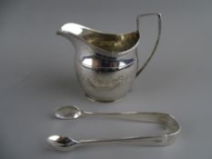 A GEORGE III SILVER CREAM JUG and a pair of later sugar tongs, London 1802 and 1926 respectively,