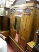 A CARVED OAK SINGLE MIRRORED DOOR WARDROBE with lower drawer, 218 cms high, 126 cms wide maximum, 44