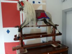 AN ANTIQUE DAPPLE GREY ROCKING HORSE with white mane and tail on a trestle stand, 114 cms high,