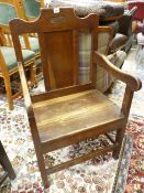 AN OAK EISTEDDFOD TYPE ARMCHAIR dated 1905, 97 cms high, 56 cms wide, 43 cms deep overall