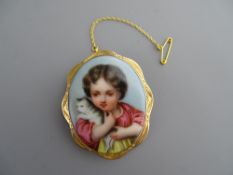 A NINE CARAT GOLD FRAMED PORCELAIN BROOCH of a little girl with her pet kitten