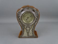 A SILVER FRONTED OAK MANTEL CLOCK in the Art Nouveau style, Birmingham 1909, 15.5 cms high