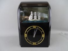A VITASCOPE BLACK BAKELITE AUTOMATON CLOCK with numerical dial and threemaster ship
