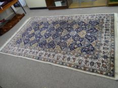 A PERSIAN STYLE 100% WOOL HAND KNOTTED CARPET, cream and blue ground with central repeating