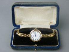 A NINE CARAT GOLD LADY'S WRISTWATCH with bracelet strap, the white enamel dial marked 'Rolco', 17.