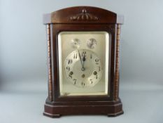 A MAHOGANY ENCASED JUNGHANS MANTEL CLOCK with silvered dial and having an eight day striking