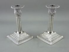 A PAIR OF SILVER CORINTHIAN COLUMN CANDLEHOLDERS on a stepped base, 13.5 cms high, Sheffield 1894