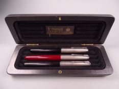 Three vintage Parker 51 fountain pens (two black, one burgundy) each with Lustraloy caps and