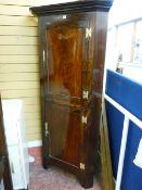 AN EARLY VICTORIAN MAHOGANY STANDING CORNER CUPBOARD with panelled doors and pierced brassware,