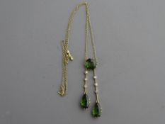 A BELIEVED SILVER FINE LINK NECK CHAIN with three pendant peridots, one circular cut and two pear