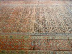 A LARGE RED GROUND PATTERNED WOOLLEN CARPET with multiple border, 453 x 340 cms (quite worn with