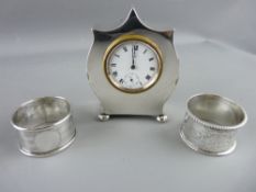 A NEAT ALL SILVER BEDROOM CLOCK, Chester, date mark rubbed, along with 2 silver napkin rings