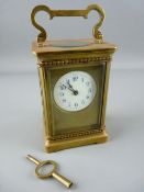 A FRENCH GILT BRASS CARRIAGE CLOCK, the enamel dial with blue Arabic numerals and satin gilt mask,