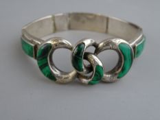 A SILVER & MALACHITE BANGLE having five oblong malachite panels with a quadruple silver and