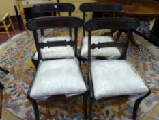 A SET OF FOUR REGENCY MAHOGANY DINING CHAIRS with carved back rails, loose pad seats and sabre front