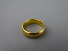 A TWENTY TWO CARAT GOLD WIDE WEDDING BAND, 7.3 grms