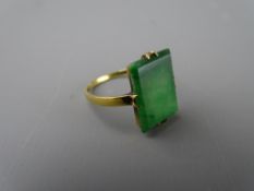 AN EIGHTEEN CARAT GOLD DRESS RING with plain oblong emerald, 1.4 x 1 cms, size 'P', 2.7 grms