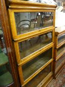 A GLOBE WERNICKE LIGHT OAK FOUR SECTION STACKING BOOKCASE with labels, 161 cms high, 87 cms wide, 31