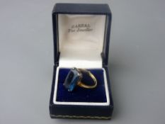 AN EIGHTEEN CARAT GOLD DRESS RING set with a 17mm rectangular blue topaz, ring size 'P', 4.7 grms