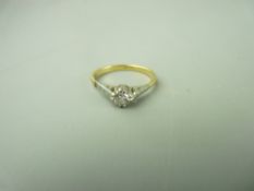 AN EIGHTEEN CARAT GOLD DIAMOND SOLITAIRE RING, the round cut solitaire set in platinum shoulders